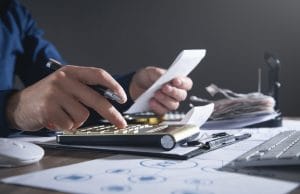 businessman using calculator holding bills business