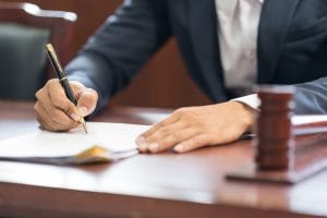 closeup judge wooden gavel sounding block man handwriting background