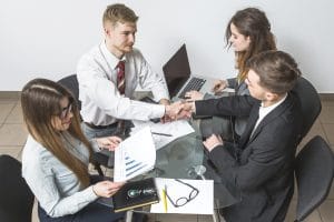 elevated view businessman shaking hands with his partner workplace