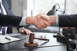 male lawyer with client shaking hands office