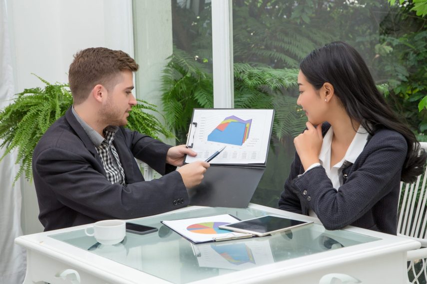 Young successful business couple is talking and viewing documents  while working in living room,Business Concept.